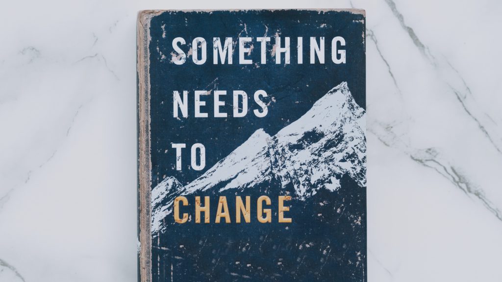 Worn book cover title, "Something Needs to Change"